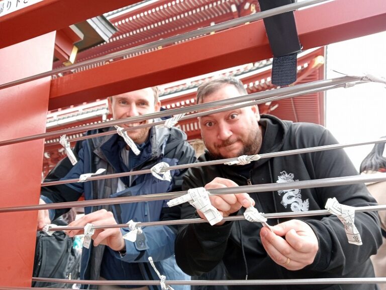 Two guests tying an omikuji at Sensoji Temple, Asakusa, Tokyo.