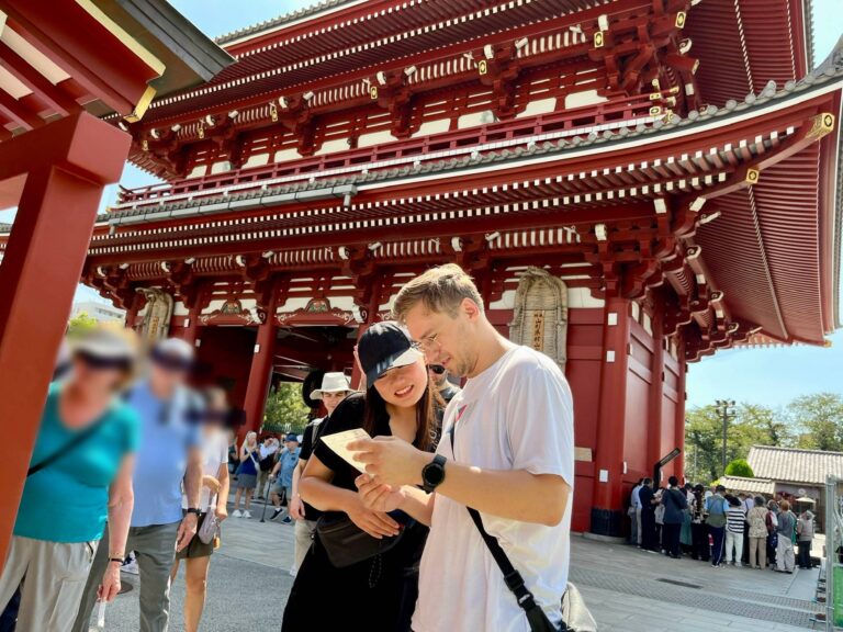 Tour guests are very interested in reading what their fortune telling says at Sensoji Temple, Asakusa, Tokyo.