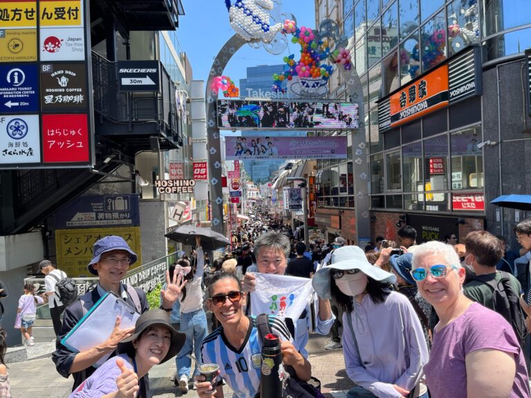 Three guests with three guides at the entrance of Takeshita Street, Harajuku.