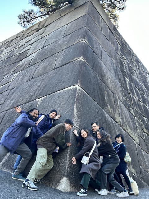 Small group tour by the stone wall at the Imperial Palace in Tokyo.