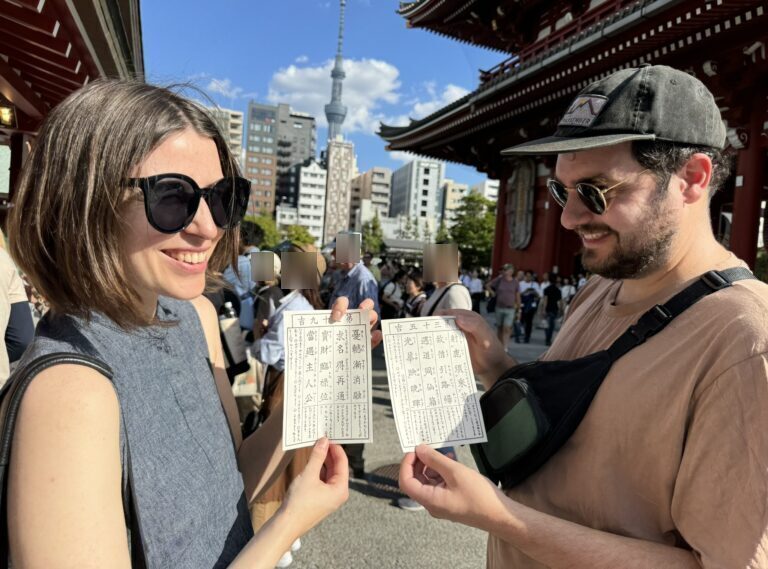 Smiling with fortune-telling paper at Sensoji Temple, Asakusa, Tokyo.